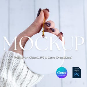 May include: A white, round ceramic ornament held by a hand with dark nail polish. The ornament has a gold string for hanging. The word "MOCKUP" is displayed on the ornament. The image also includes the text "PSD (Smart Object), JPG & Canva (Drag & Drop)".