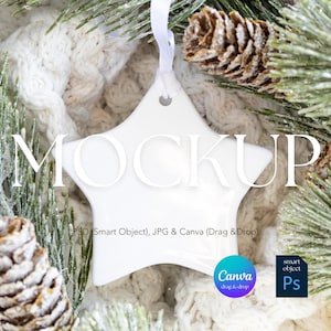 May include: A white star-shaped ornament with the word "MOCKUP" in white. The ornament hangs from a white ribbon. The background includes pine branches, pine cones, and a knitted white blanket. The image also includes the Canva and Photoshop logos.