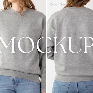 May include: A carbon grey sweatshirt with the word "MOCKUP" in large white letters. The sweatshirt is shown from the front and back, with a crew neck and long sleeves. The model is wearing blue jeans.