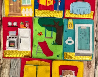 May include: A felt quiet book with eight pages featuring different scenes, including a house, a living room, a dining room, a kitchen, a backyard, a bathroom, a bedroom, and a closet. Each page has a flap that can be lifted to reveal a hidden object or scene.