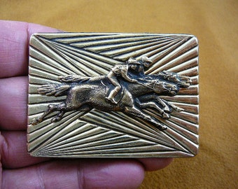 May include: A gold-toned metal belt buckle with a raised design of two horses racing. The buckle has a textured background with a sunburst pattern.