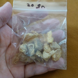May include: A clear plastic bag containing a small amount of amber resin. The bag is labeled "20 gm".