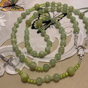 Katholieke rozenkrans groene calcietkralen die vloeien onder zwart licht Italiaanse zilveren medaille en kruis Zeer ontspannende kleur