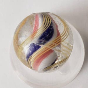 Antique Marble--  red white and blue ribbon swirl marble with yellow latticino outside swirls. D