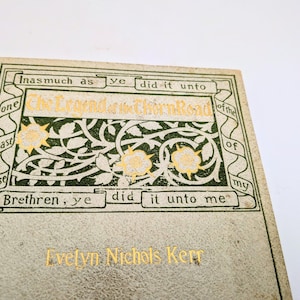 Pu&ograve; includere: Primo piano di un libro d'epoca intitolato "The Legend of the Thorn Road" di Evelyn Nichols Kerr. La copertina &egrave; bianco sporco con scritte dorate e decorazioni floreali verdi e dorate. Il titolo del libro &egrave; in oro.