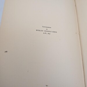 Pu&ograve; includere: Pagine di un libro aperto con il testo "Copyrighted by Evelyn Nichols Kerr A.D., 1897". Le pagine sono bianco sporco con alcune piccole macchie scure. Il testo &egrave; in un carattere serif.