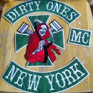 Op de afbeelding: Groene en witte geborduurde motorfiets patch set met de woorden "Dirty Ones MC New York". De patch set heeft een schedel met een zeis en zuigers.
