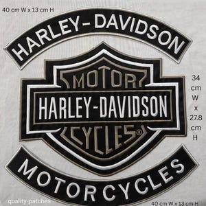 Pode incluir: Conjunto de três patches Harley-Davidson em preto e branco. O maior patch tem a forma de um escudo com as palavras "HARLEY-DAVIDSON" e "MOTOR CYCLES". Os patches superior e inferior são curvos, cada um com "HARLEY-DAVIDSON" e "MOTORCYCLES". O maior patch tem 34 cm de largura e 27,8 cm de altura.