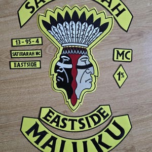 Op de afbeelding: Gele en zwarte motorclub patch set met de woorden "Satudarah MC Eastside Maluku" en een indiaanse hoofdtooi met twee gezichten. De patch bevat ook de nummers "13-95-4" en "1%".