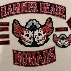 May include: A set of embroidered patches featuring a skull and crossbones design with flames. The patches are black, red, and white and include the text "HAMMER HEADZ", "NOMADS", "PRESIDENT", "HAMMER HEADZ", "BAD BOYS", "HFFH", and "1%er HFFH".