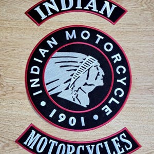 May include: Three embroidered patches for a motorcycle jacket. The centre patch is round and black with a red border. It features a white Indian head logo and the text "INDIAN MOTORCYCLE 1901". The top and bottom patches are black with red borders and white text. The top patch says "INDIAN" and the bottom patch says "MOTORCYCLES".