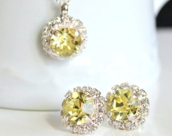 May include: A silver necklace and earrings set with a large yellow crystal surrounded by smaller clear crystals.