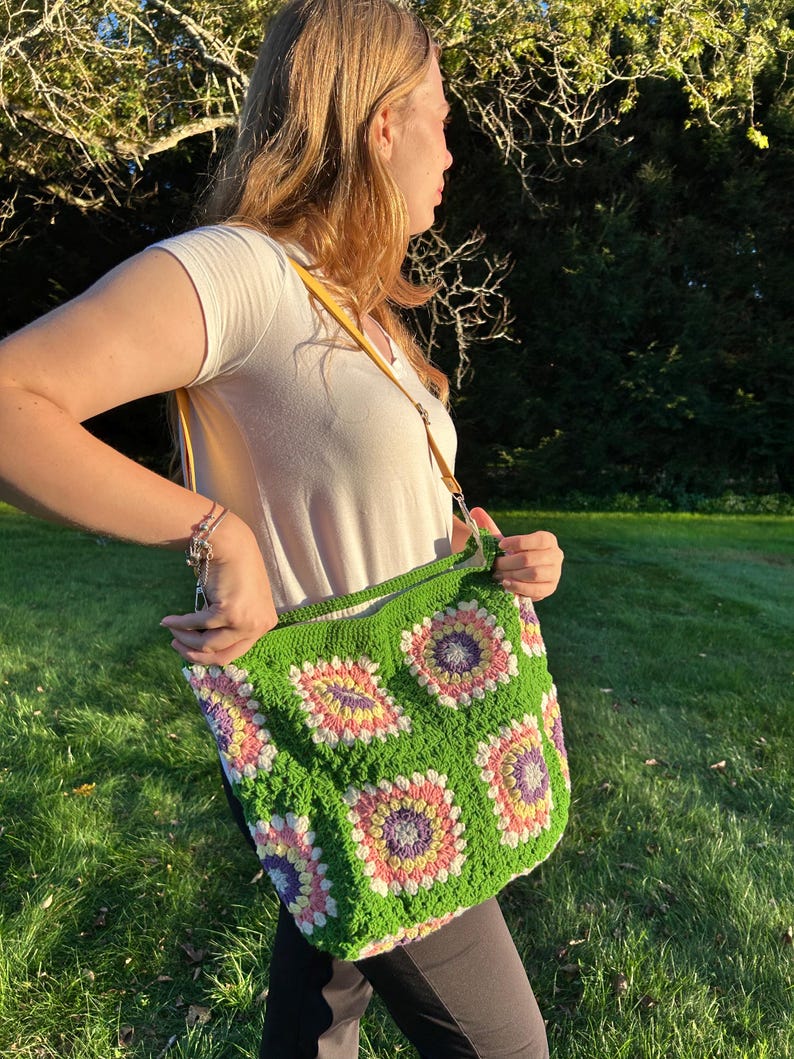colorful granny square crossbody bag,handmade crochet shoulder bag adjustable,vintage circular flower bag leather strap,boho crossbody bag lined,retro granny square purse handmade,adjustable leather strap shoulder bag,festival crossbody bag colorful,lined crochet bag secure closure,gift for her crossbody bag,vintage style shoulder bag handmade,bright granny square bag,hands free crossbody crochet,travel bag adjustable strap,unique handmade purse granny square,sustainable fashion crossbody bag