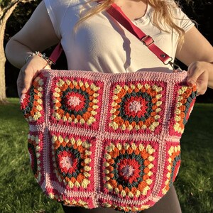 colorful granny square crossbody bag,handmade crochet shoulder bag adjustable,vintage circular flower bag leather strap,boho crossbody bag lined,retro granny square purse handmade,adjustable leather strap shoulder bag,festival crossbody bag colorful,lined crochet bag secure closure,gift for her crossbody bag,vintage style shoulder bag handmade,bright granny square bag,hands free crossbody crochet,travel bag adjustable strap,unique handmade purse granny square,sustainable fashion crossbody bag