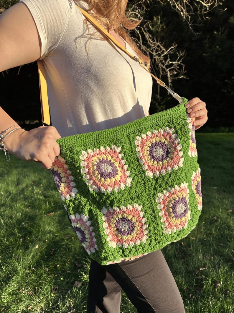 colorful granny square crossbody bag,handmade crochet shoulder bag adjustable,vintage circular flower bag leather strap,boho crossbody bag lined,retro granny square purse handmade,adjustable leather strap shoulder bag,festival crossbody bag colorful,lined crochet bag secure closure,gift for her crossbody bag,vintage style shoulder bag handmade,bright granny square bag,hands free crossbody crochet,travel bag adjustable strap,unique handmade purse granny square,sustainable fashion crossbody bag