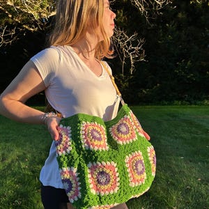 colorful granny square crossbody bag,handmade crochet shoulder bag adjustable,vintage circular flower bag leather strap,boho crossbody bag lined,retro granny square purse handmade,adjustable leather strap shoulder bag,festival crossbody bag colorful,lined crochet bag secure closure,gift for her crossbody bag,vintage style shoulder bag handmade,bright granny square bag,hands free crossbody crochet,travel bag adjustable strap,unique handmade purse granny square,sustainable fashion crossbody bag