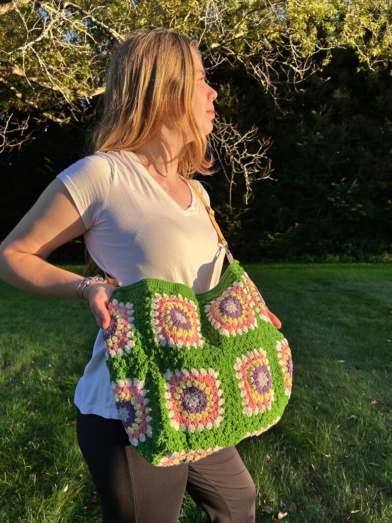 colorful granny square crossbody bag,handmade crochet shoulder bag adjustable,vintage circular flower bag leather strap,boho crossbody bag lined,retro granny square purse handmade,adjustable leather strap shoulder bag,festival crossbody bag colorful,lined crochet bag secure closure,gift for her crossbody bag,vintage style shoulder bag handmade,bright granny square bag,hands free crossbody crochet,travel bag adjustable strap,unique handmade purse granny square,sustainable fashion crossbody bag