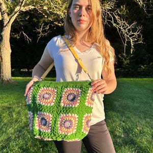 colorful granny square crossbody bag,handmade crochet shoulder bag adjustable,vintage circular flower bag leather strap,boho crossbody bag lined,retro granny square purse handmade,adjustable leather strap shoulder bag,festival crossbody bag colorful,lined crochet bag secure closure,gift for her crossbody bag,vintage style shoulder bag handmade,bright granny square bag,hands free crossbody crochet,travel bag adjustable strap,unique handmade purse granny square,sustainable fashion crossbody bag