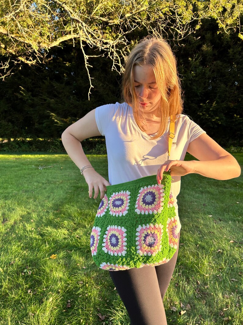 colorful granny square crossbody bag,handmade crochet shoulder bag adjustable,vintage circular flower bag leather strap,boho crossbody bag lined,retro granny square purse handmade,adjustable leather strap shoulder bag,festival crossbody bag colorful,lined crochet bag secure closure,gift for her crossbody bag,vintage style shoulder bag handmade,bright granny square bag,hands free crossbody crochet,travel bag adjustable strap,unique handmade purse granny square,sustainable fashion crossbody bag
