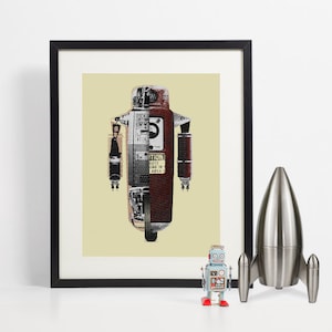Könnte beinhalten: Gerahmter Kunstdruck einer Roboterillustration in Rot, Silber und Schwarz. Der Roboter hat eine Vintage-Ästhetik, wobei das Wort "CAUTION" sichtbar ist. Ein kleiner Spielzeugroboter und eine silberne Rakete stehen auf dem Regal darunter.