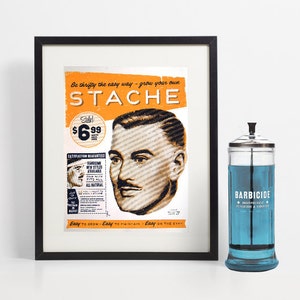 以下が含まれることがあります： オレンジ色の「STACHE」の文字と男性の肖像画が描かれた、額入りのヴィンテージ風プリント。その隣には、青い液体が入った「BARBICIDE」と書かれたガラス瓶があります。プリントには「Easy to grow - Easy to maintain - Easy on the eye.」というテキストが含まれています。