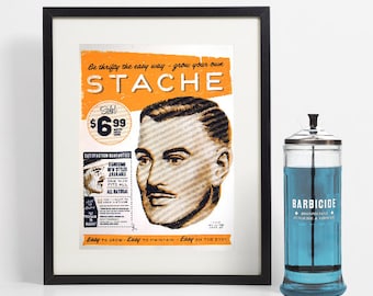 May include: Framed vintage-style print with the word "STACHE" in orange and a man's portrait. Next to it is a glass jar labeled "BARBICIDE" with blue liquid inside. The print includes text: "Easy to grow - Easy to maintain - Easy on the eye."