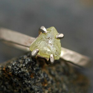 May include: A gold ring with a rough, triangular, yellow diamond.
