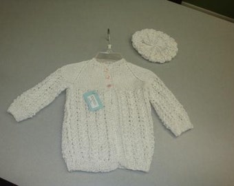 May include: White crocheted baby sweater with a button closure and a matching white crocheted hat.