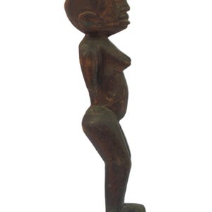 以下が含まれることがあります： 黒いハンドルと「But First, Coffee」のテキストが黒い太字で書かれた白いセラミックマグ。マグは木製の表面に置かれています。