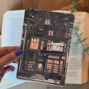 May include: A rectangular bookmark featuring a detailed illustration of a gothic building with the text "THE ARCHIVES". The building is dark with illuminated windows, a dragon, and the letters "BWC". The bookmark has a night sky background with stars.