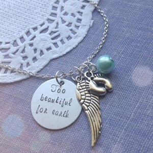 Puede incluir: Collar de plata con un dije que dice "Demasiado hermoso para la tierra" y presenta un ala de &aacute;ngel peque&ntilde;a y una cuenta azul claro.