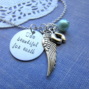Puede incluir: Collar de plata con un dije que dice "Demasiado hermoso para la tierra" y un dije de ala de &aacute;ngel de plata. El collar tambi&eacute;n tiene una cuenta azul claro.
