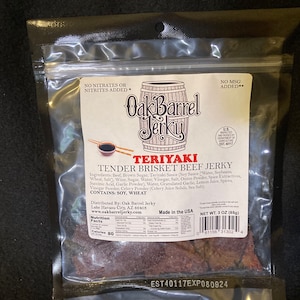 May include: A bag of Oak Barrel Teriyaki Tender Brisket Beef Jerky. The bag is white with a brown and white illustration of a barrel. The bag has a nutrition facts label and a net weight of 3 ounces (85 grams).
