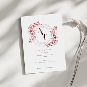 Op de afbeelding: Save the date kaart met een bloemenkransontwerp in tinten rood en wit. De initialen "A" en "T" staan in een cirkel in het midden van de krans. De tekst "Angela & Travis" staat onder de krans, gevolgd door de datum en tijd van de gebeurtenis, en het adres van de locatie. De tekst "RSVP at www.reallygreatsite.com" staat onderaan de kaart.