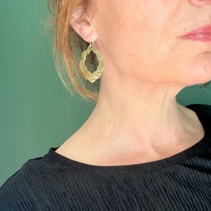 Puede incluir: Pendientes de oro con un diseño texturizado y calado. Los pendientes tienen forma de trébol de cuatro hojas.