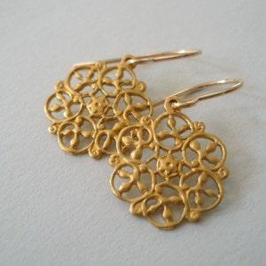 Op de afbeelding: Gouden filigraan oorbellen met een delicaat bloemenmotief. De oorbellen hebben een haaksluiting.