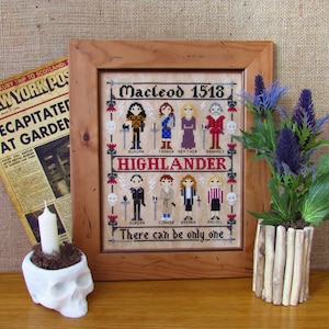 May include: A framed cross-stitch embroidery depicting characters from the TV show Highlander. The embroidery features the text "Macleod 1518" and "Highlander". The text "There can be only one" is at the bottom of the embroidery.