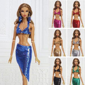 May include: A fashion doll wearing a blue sequin bikini top and skirt. The doll has long brown hair and is wearing large blue earrings. Additional dolls are shown wearing sequin bikini sets in pink, red, gold, silver, black, and green.
