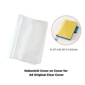 Könnte beinhalten: Transparente Hobonichi Cover on Cover für A6 Original Notizbücher. Die Hülle ist 177 mm hoch, 257 mm breit und 0,8 mm dick. Das Bild zeigt auch ein gelbes Notizbuch in der Hülle.