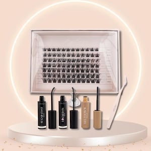 May include: A beauty product set featuring a clear box of individual black eyelashes, several black mascara tubes, a tan tube, and a white tweezer. The products are arranged on a white pedestal with a soft, neutral background.