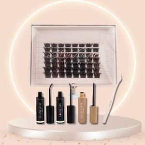May include: A beauty product set featuring a clear box of false eyelashes, several black mascara tubes, a beige tube, and a pair of white tweezers. The products are arranged on a white platform with a soft pink background and a glowing white circle.