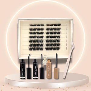 May include: A beauty product set featuring a tray of individual black lash clusters, applicators, and tubes of lash products. The products are arranged on a white pedestal with a soft pink background and a glowing circular light.