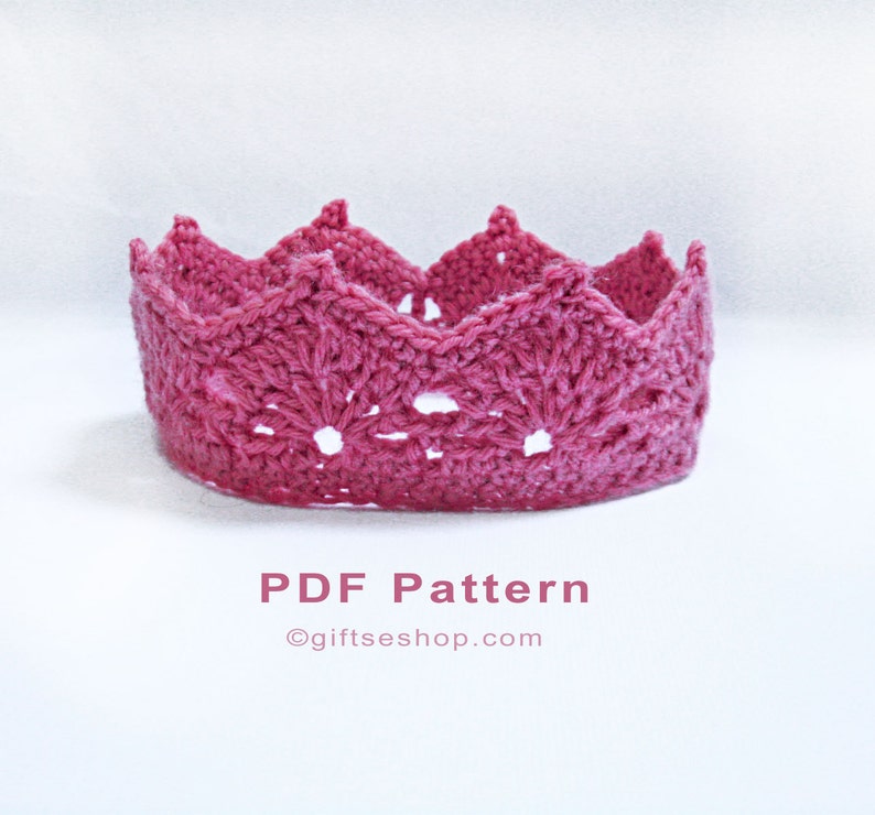 Op de afbeelding: Een roze gehaakte kroon met een kantpatroon. De kroon staat op een witte achtergrond. PDF-patroon &copy;giftseshop.com