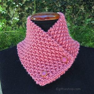 Peut inclure: Un col en crochet rose avec deux boutons roses. Le col est sur un mannequin noir.