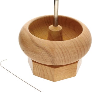 Könnte beinhalten: Ein Holzringmandrel mit einem Metallpin und einer sechseckigen Basis. Der Mandrel wird verwendet, um Ringe zu dimensionieren und zu formen.