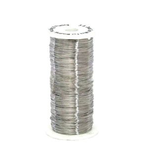 Può includere: Un rotolo di filo argentato per la rilegatura. Il rotolo è etichettato "Wire for Binding - S.S. Plating".