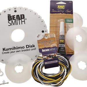 May include: A craft kit for making braided cords. The kit includes a white Kumihimo disk with the text "Kumihimo Disk Create your own braided cord!", a tube of ZAP Jewelry Gel, and spools of cord in various colors. Also included are several white plastic disks and jewelry findings.