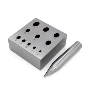 May include: A metal ring mandrel with 13 different sized holes for sizing rings. The mandrel is silver in colour and has numbers 4 through 14 printed on it. A silver metal mandrel tool is also included.