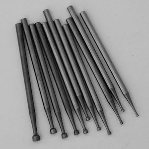Puede incluir: Un conjunto de 12 herramientas de metal plateado con puntas redondeadas. Las herramientas están dispuestas en forma de abanico, con las puntas apuntando hacia la parte inferior de la imagen.