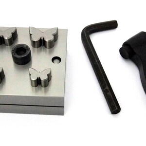 May include: A metal punch set with four butterfly-shaped punches and a black handle. The set includes a wrench for adjusting the punch.